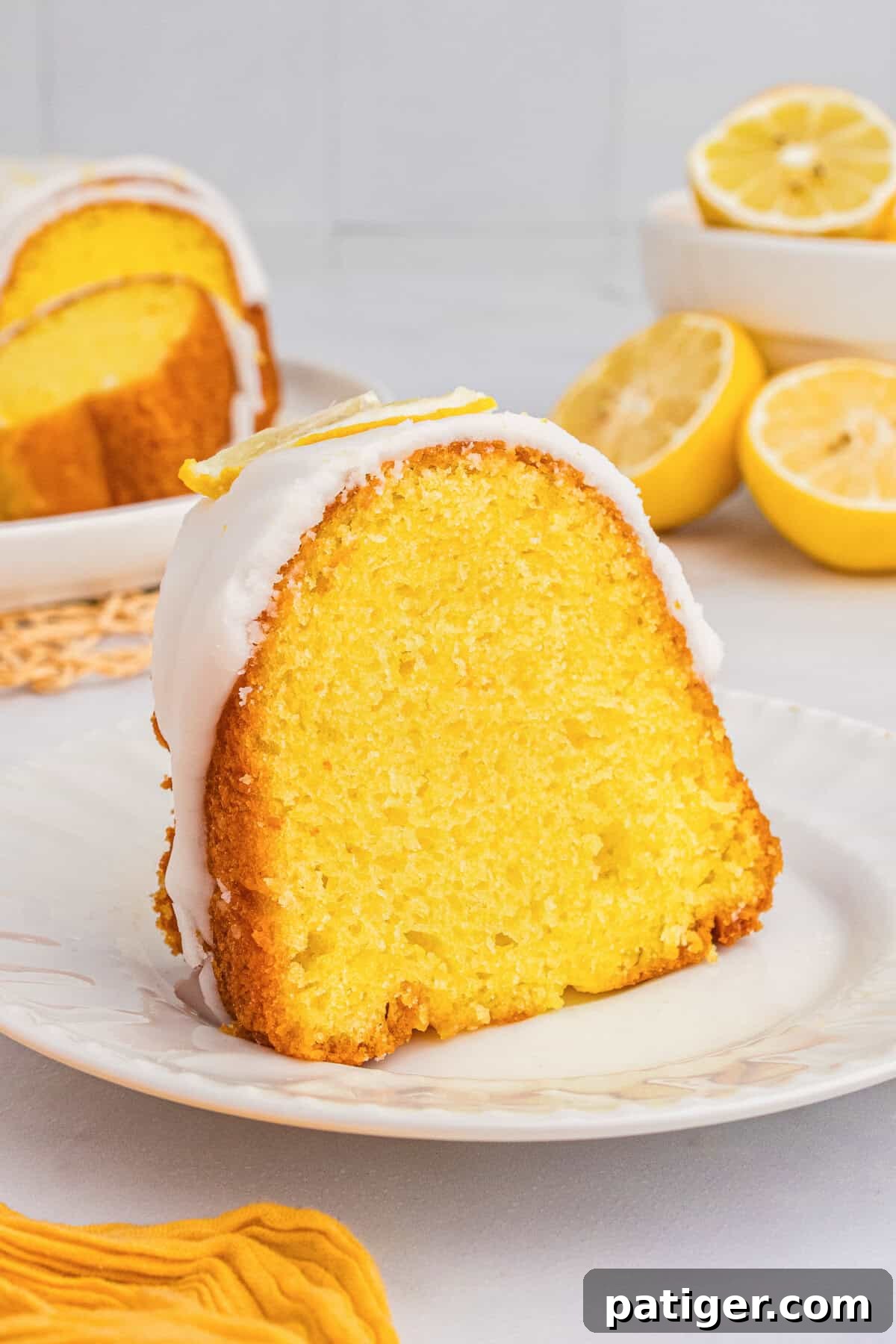 Slice of lemon pudding bundt cake with cake mix on a white plate.