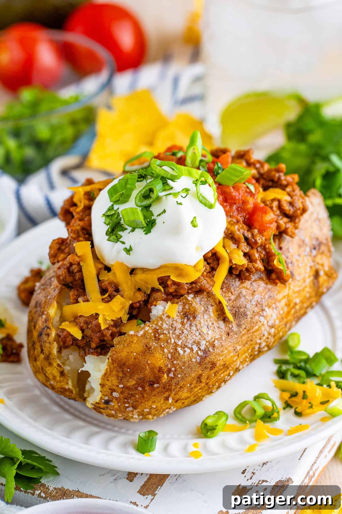 Taco Spud Boats 2 Taco stuffed baked potato- a baked potato split open and filled with taco-seasoned ground beef, topped with shredded cheese, a dollop of sour cream, salsa, cilantro, and green onions.