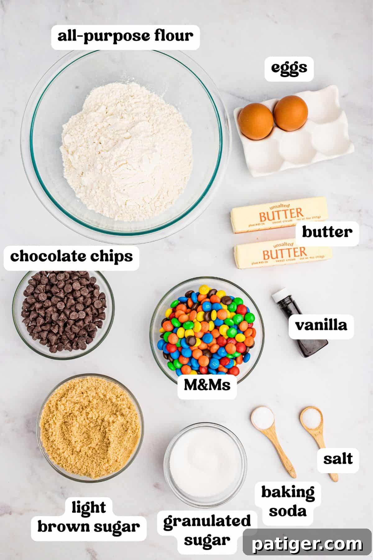 All ingredients for chocolate chip M&M cookie bars, neatly measured and arranged on a counter, ready for mixing and baking.