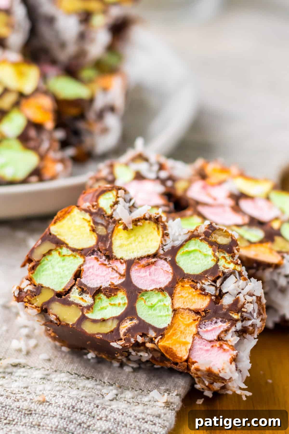 Stained Glass Cookies 6 Close-up of marshmallow-studded church window cookies with colorful mini marshmallows, chocolate, and a shredded coconut coating.