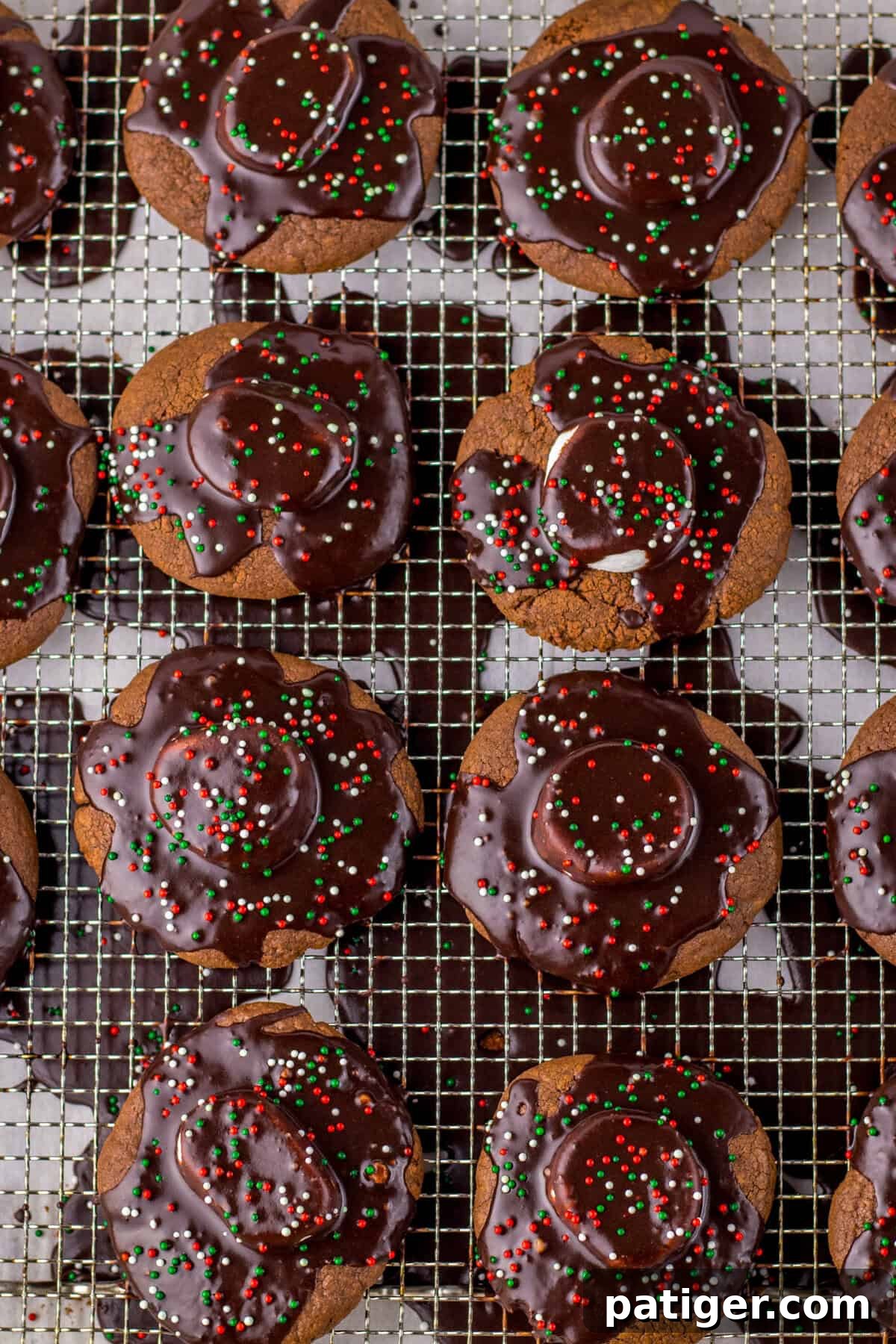Cozy Hot Cocoa Cookies 8 Hot chocolate cookies on a cooling rack with marshmallows and chocolate icing.
