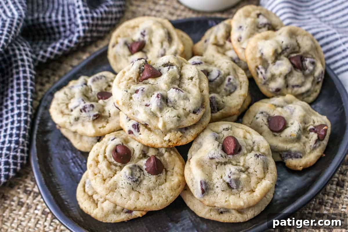 Close-up of freshly baked yogurt chocolate chip cookies on a black plate, showcasing their soft texture and abundance of melted chocolate.