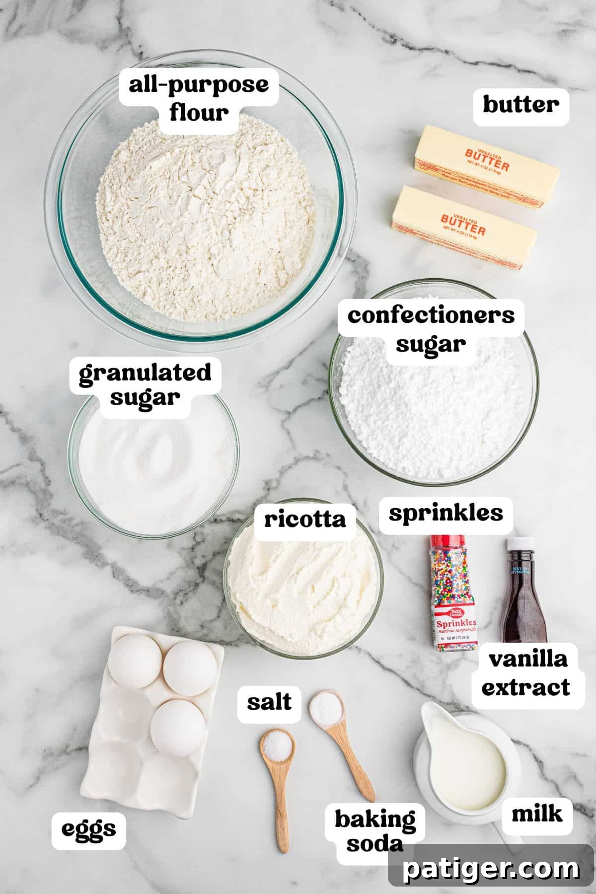 Classic Italian Ricotta Cookies 4 A top-down view of ricotta cookie ingredients labeled with text. The image includes bowls of all-purpose flour, granulated sugar, confectioners sugar, and ricotta, along with sticks of butter, eggs, salt, baking soda, milk, vanilla extract, and colorful sprinkles, all neatly arranged on a marble countertop.