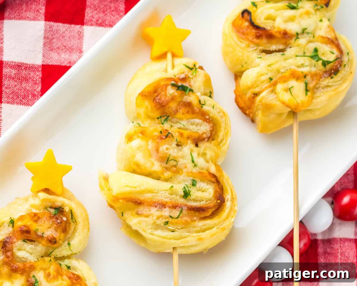 Ham and cheese puff pastry Christmas tree with crispy edges, layers of ham, melted cheese, and a parsley garnish, finished with a small cheddar star on top.