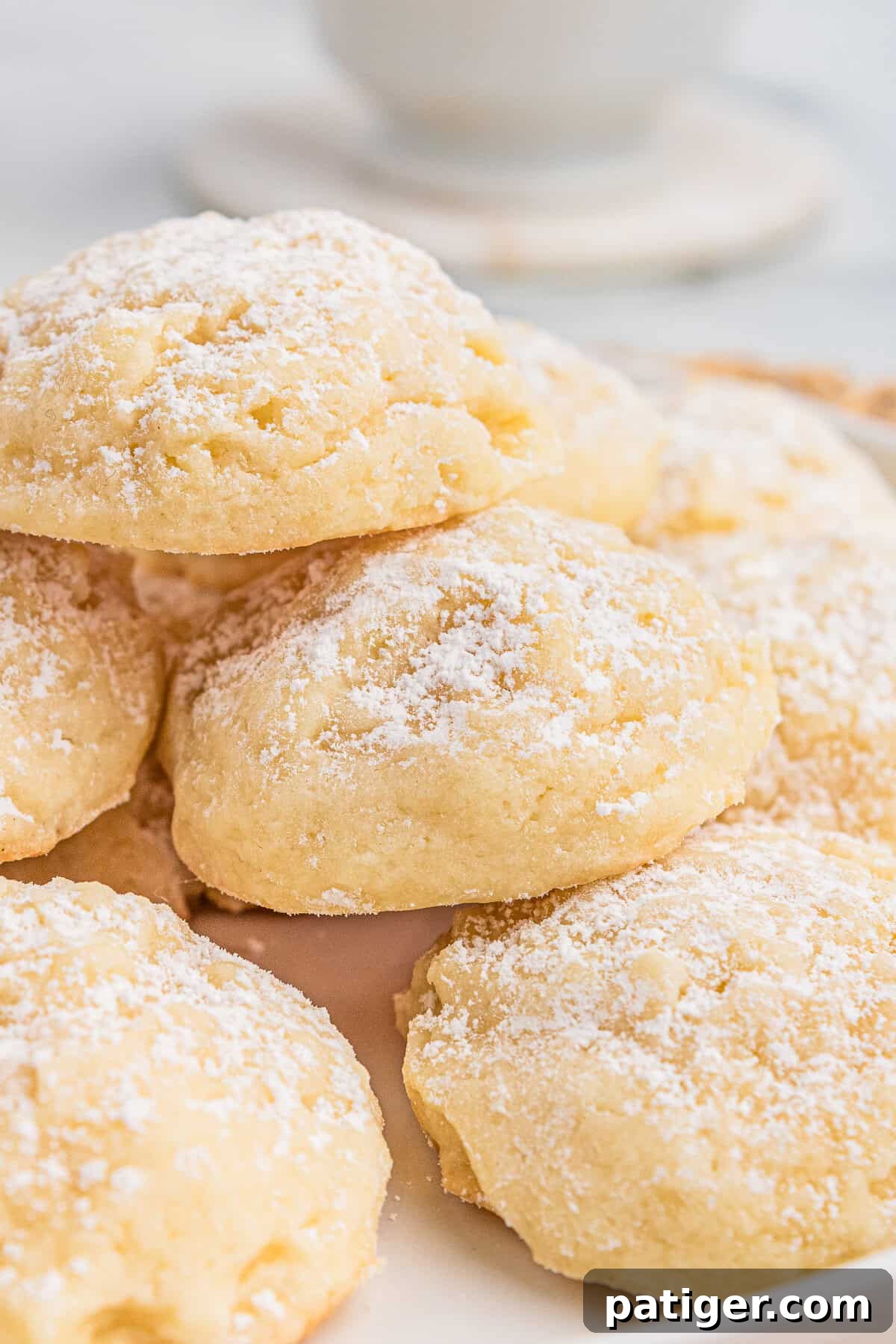 Velvety Cream Cheese Bites 8 A plate of soft cream cheese cookies with powdered sugar, emphasizing their light, delicate crumb and sugar-dusted tops.
