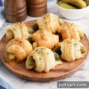 Pickles in a blanket on a wooden platter.