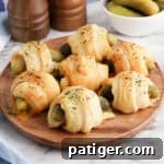 Pickles in a blanket on a wooden platter.