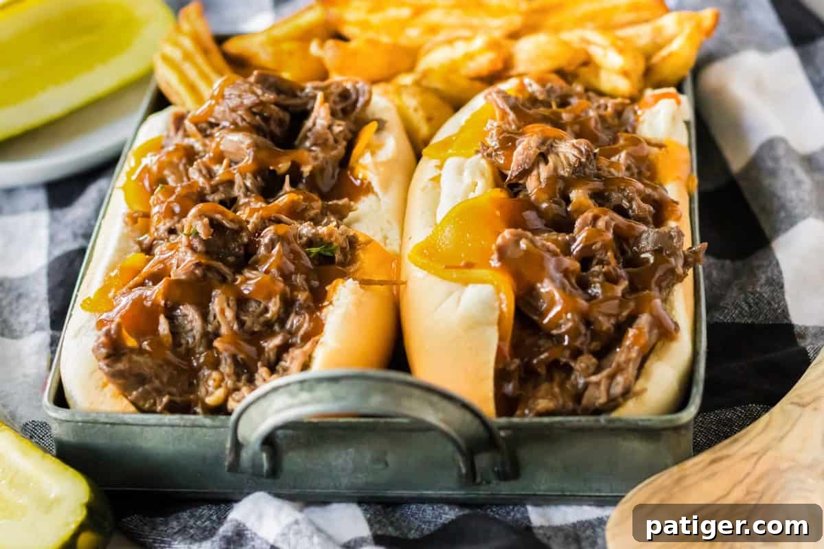 Melt-in-Your-Mouth Slow Cooker BBQ Beef 9 Slow cooker BBQ beef sandwiches with cheddar and sauce.