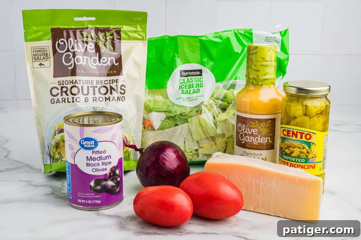 A vibrant flat lay showcasing all the fresh ingredients for the Olive Garden Salad. This includes a bag of iceberg salad mix, a bowl of crispy croutons, a selection of fresh Roma tomatoes, a red onion, a container of pitted black olives, a few bright green pepperoncini peppers, and a generous block of Parmesan cheese, alongside a bottle of Olive Garden Signature Italian Dressing. Each element is ready to be transformed into a delicious salad.