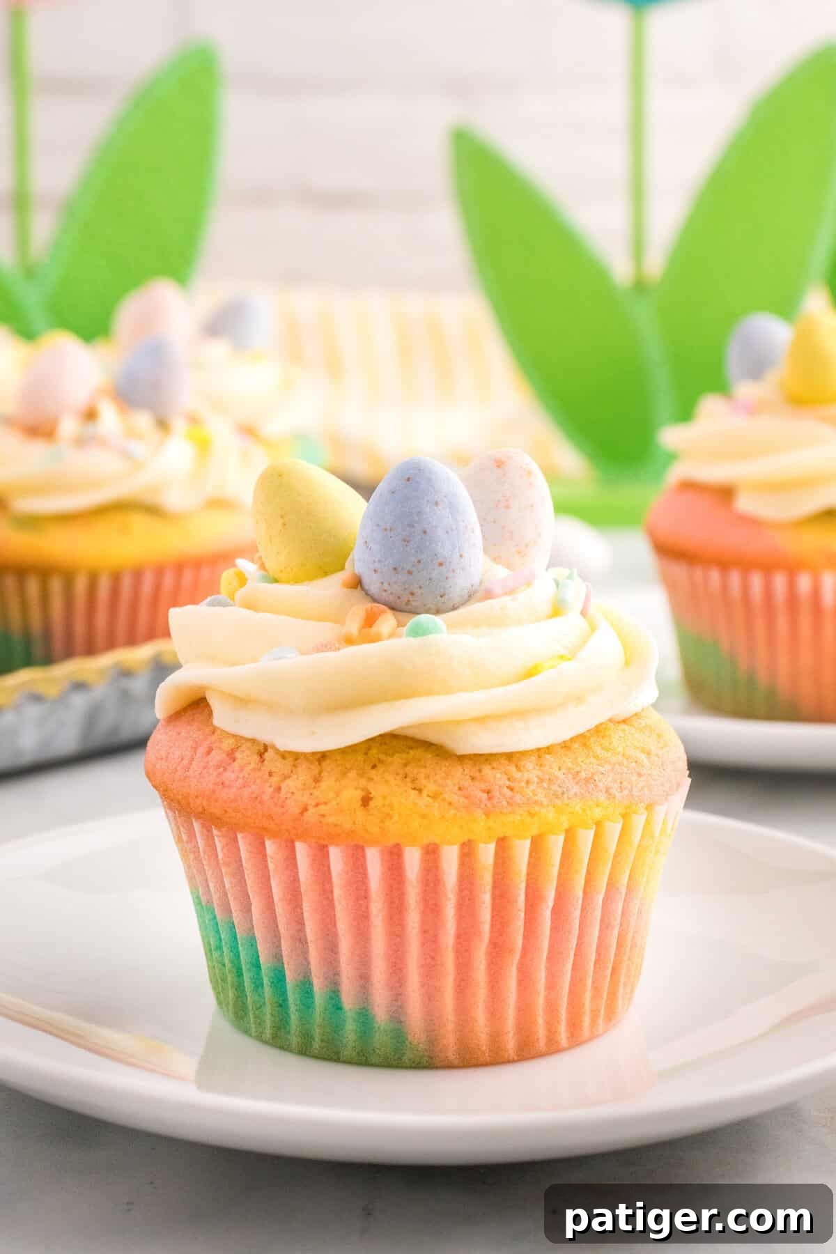 Hoppy Easter Cupcake Treats 10 A pastel Easter cupcake with piped frosting and mini eggs on a plate.