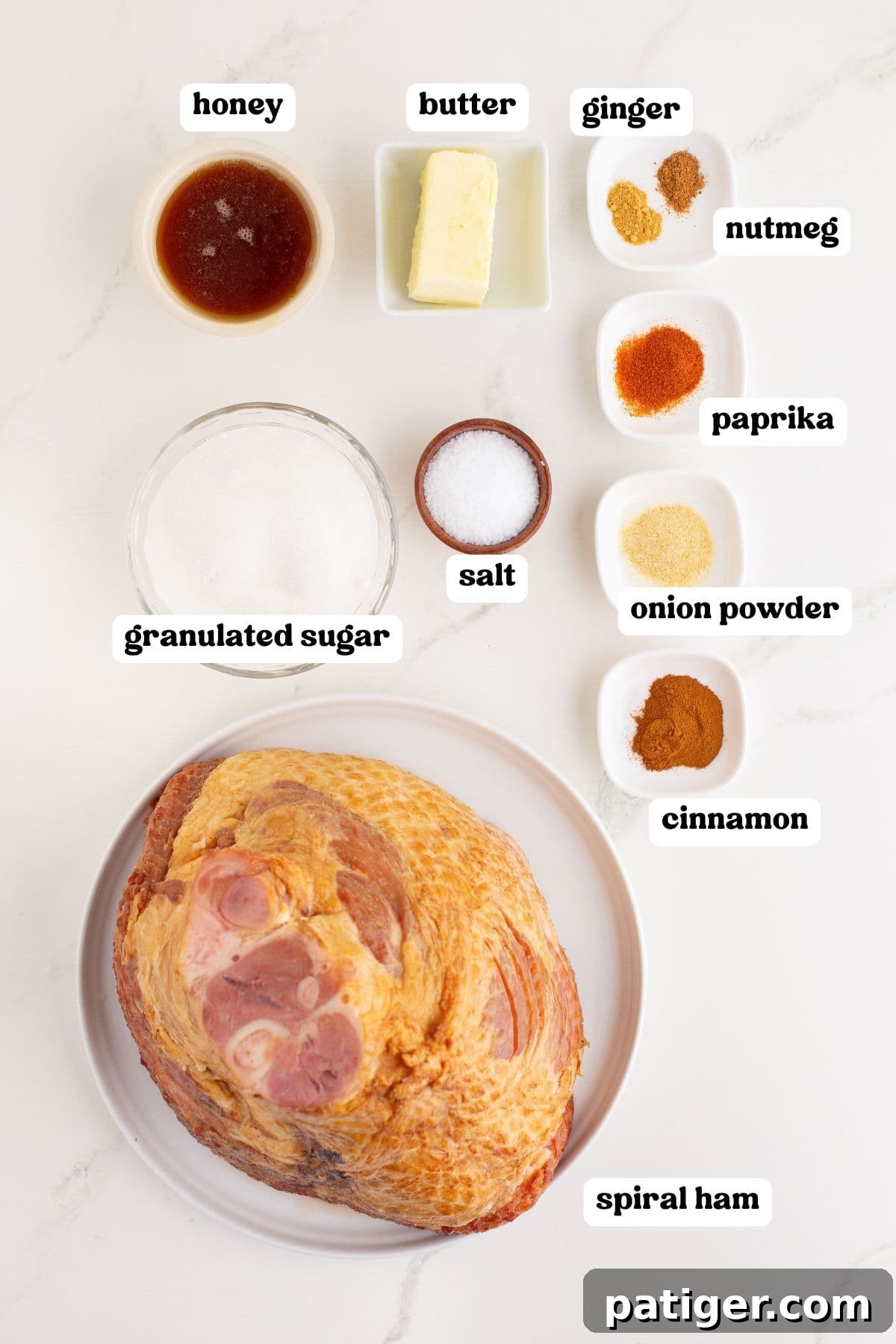 Golden Honey-Glazed Spiral Ham 4 Ingredients labeled for making the spiral honey baked ham recipe: honey, butter, granulated sugar, salt, cinnamon, onion powder, paprika, nutmeg, and ginger. A large unseasoned spiral-cut ham sits on a plate at the bottom.