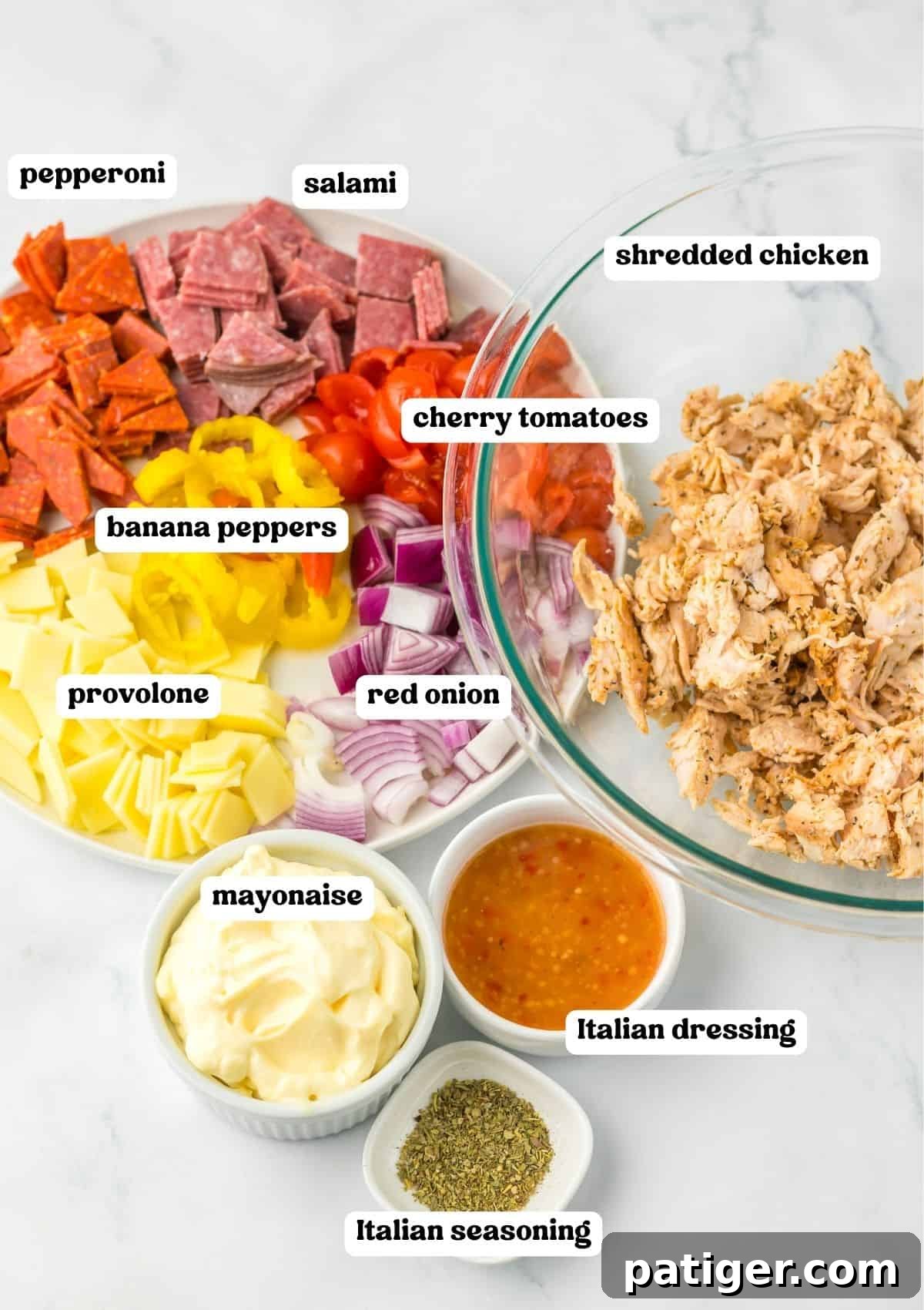  A labeled image displaying the ingredients for the recipe: pepperoni, salami, shredded chicken, cherry tomatoes, banana peppers, provolone cheese, red onion, mayonnaise, Italian dressing, and Italian seasoning.