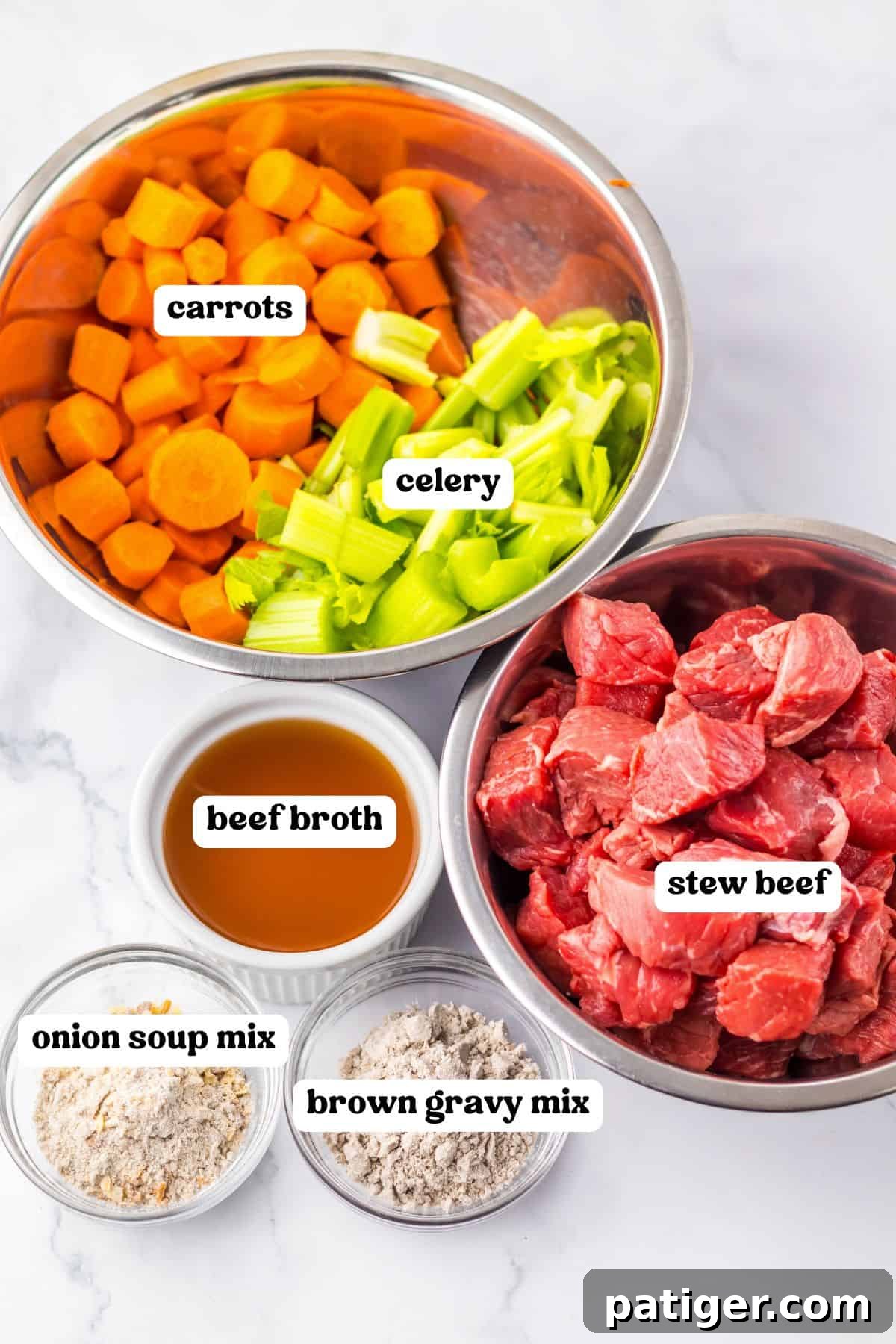 Labeled ingredients in bowls: sliced carrots and chopped celery, raw cubed stew beef, beef broth, onion soup mix, and brown gravy mix. All laid out for easy assembly.