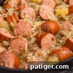 Kielbasa with sauerkraut, caraway seeds, and apple chunks in a crock pot.