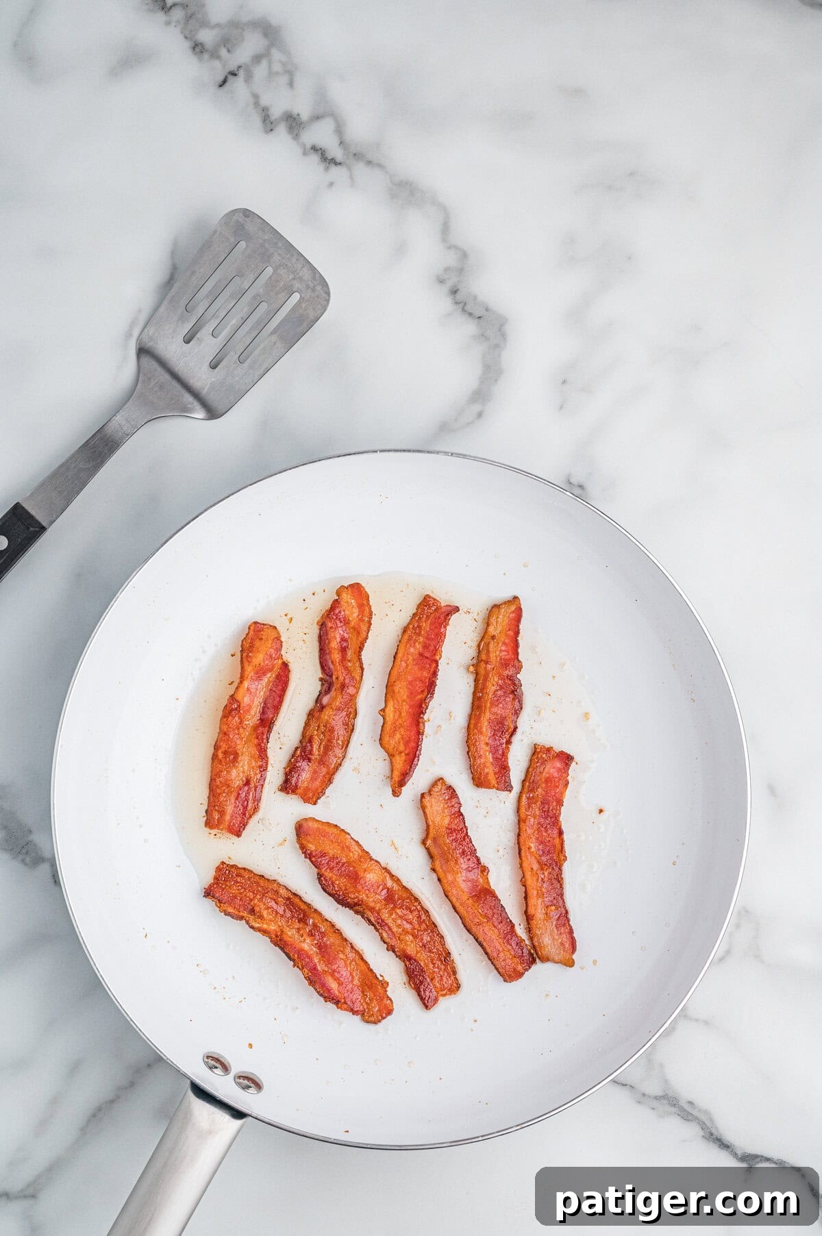 Loaded Cheesy Shrimp Grits 6 Skillet with cooked bacon strips.