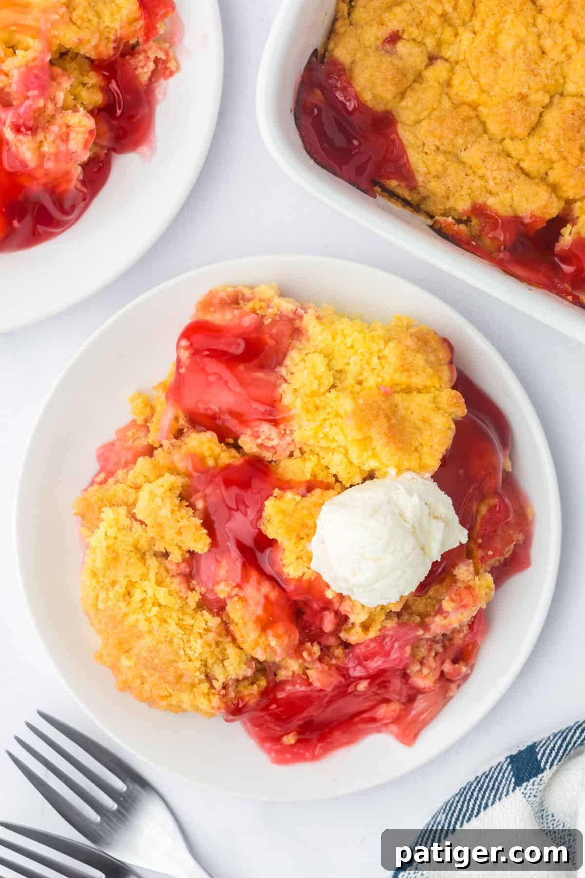 A beautifully plated serving of rhubarb dump cake, garnished with a perfectly round scoop of vanilla ice cream. The steam gently rises, indicating its warmth and inviting flavor.
