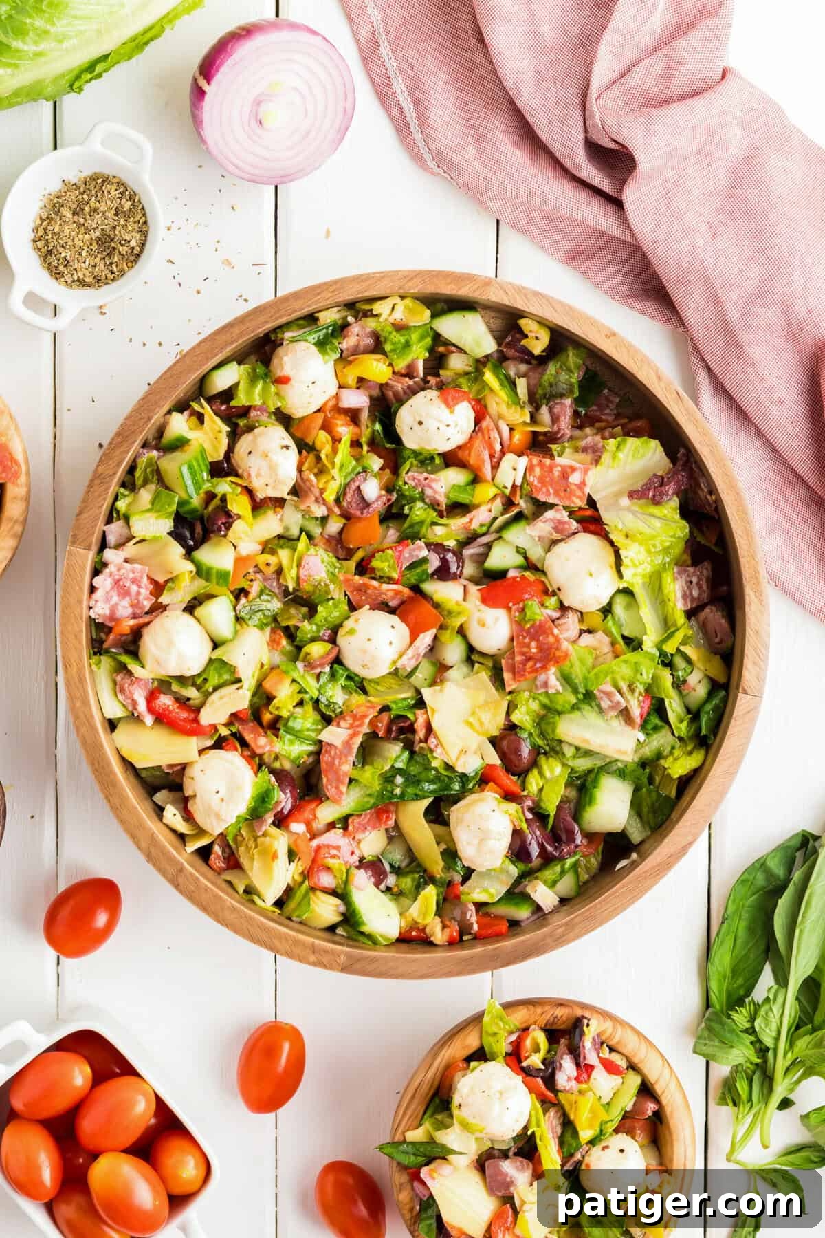  Flat lay of antipasto salad in a large and small bowl with fresh ingredients.