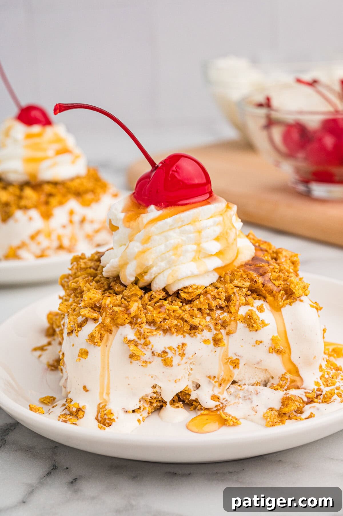 Golden Fried Ice Cream 2 Fried ice cream dessert on a white plate, coated in a crispy golden crust, topped with whipped cream, caramel drizzle, and a maraschino cherry.