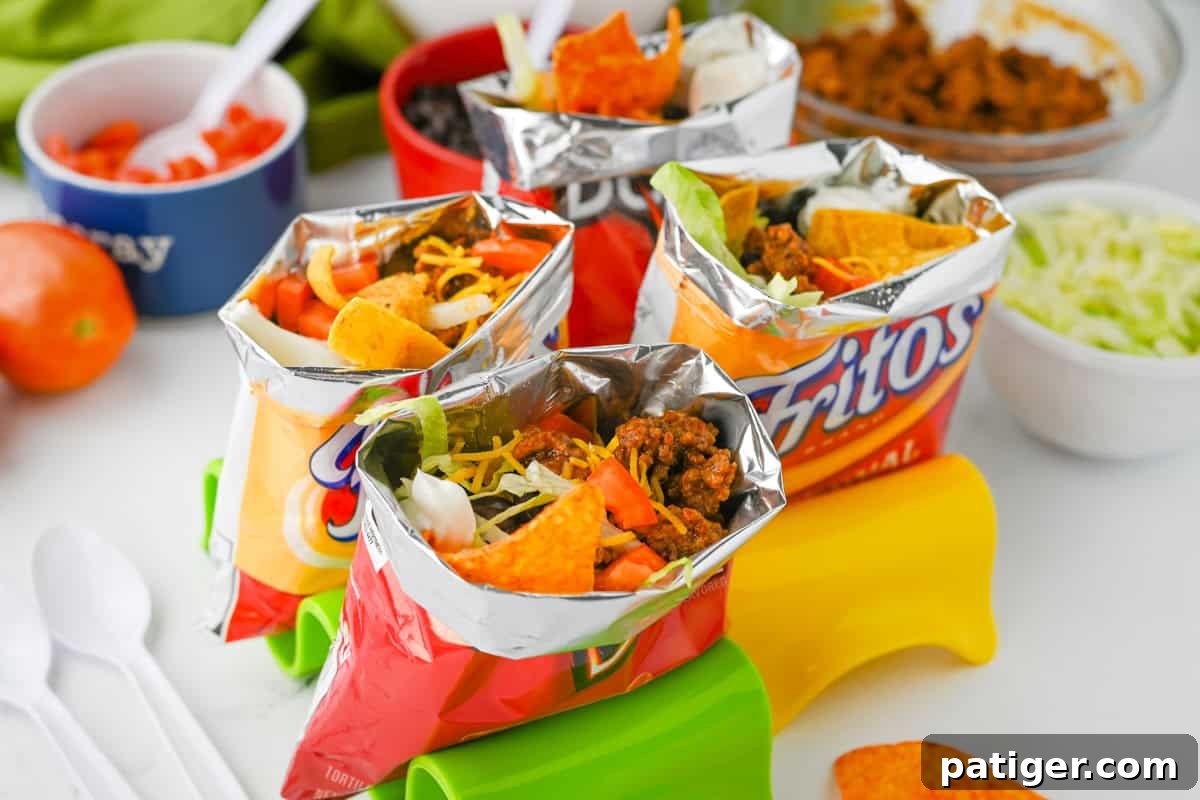 A vibrant selection of walking tacos presented in their individual chip bags, showcasing a variety of delicious toppings including seasoned meat, cheese, lettuce, and sour cream, perfect for a fun and easy meal.