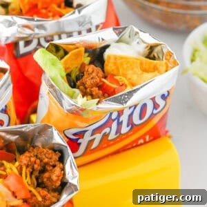 Fritos walking tacos with toppings like shredded cheese, beans, sour cream, and lettuce.