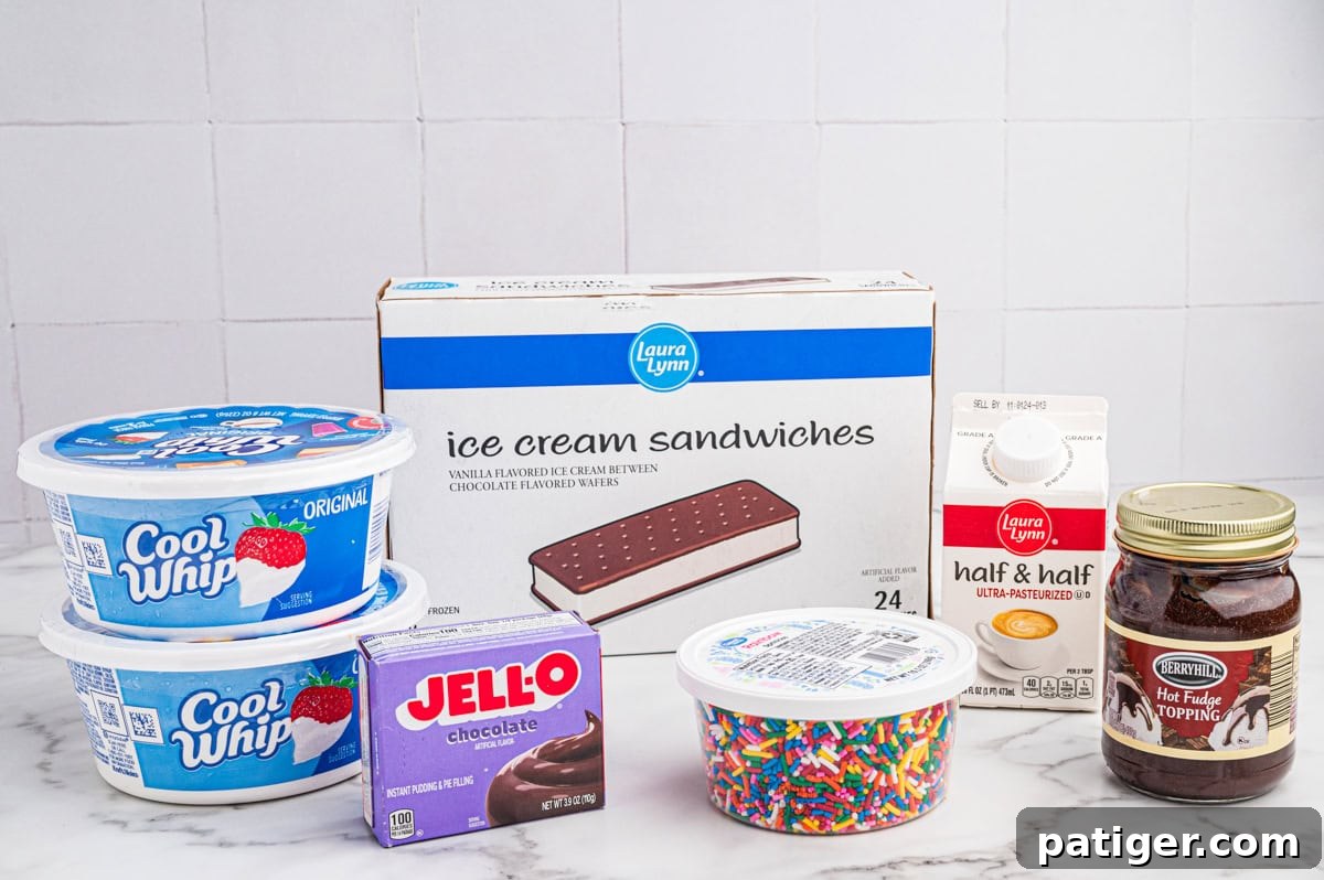 Ingredients for making an ice cream sandwich cake including two tubs of Cool Whip, a box of ice cream sandwiches, half & half, hot fudge, a rainbow sprinkles, and Jell-O chocolate instant pudding mix.