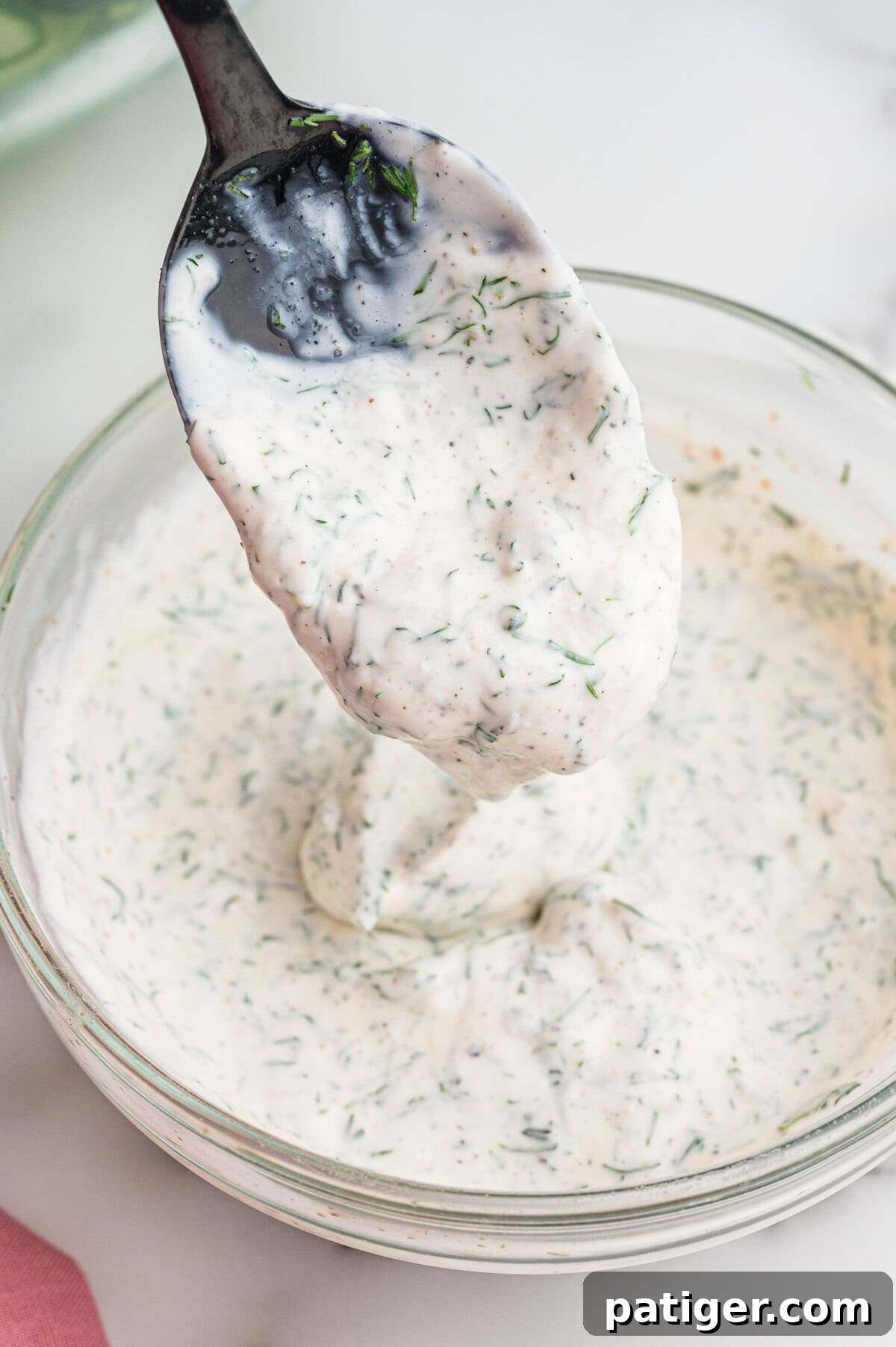 A thick, creamy white dressing speckled with chopped dill.