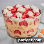 Strawberry banana pudding layered with fruit, pudding, and whipped cream in a trifle dish.