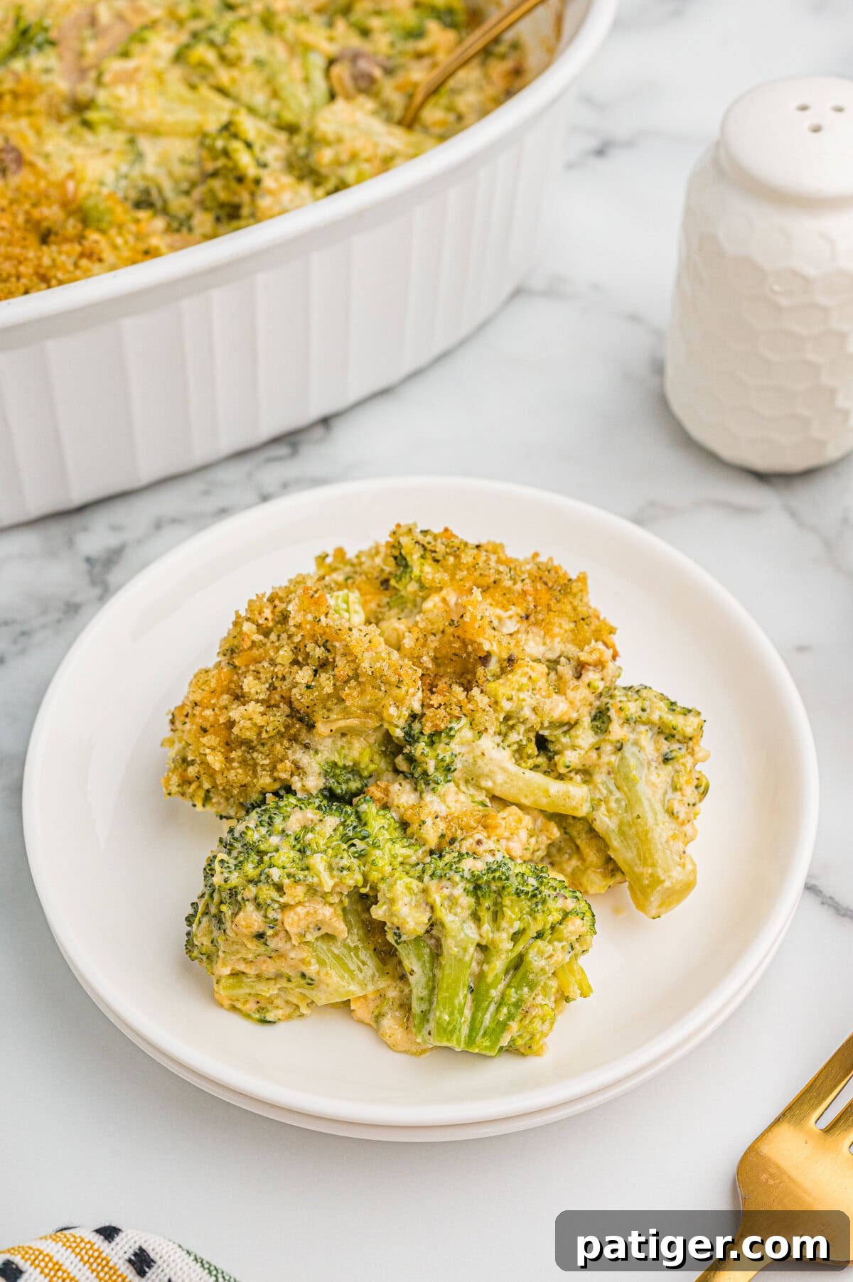 Serving of broccoli cheese casserole on a white plate.
