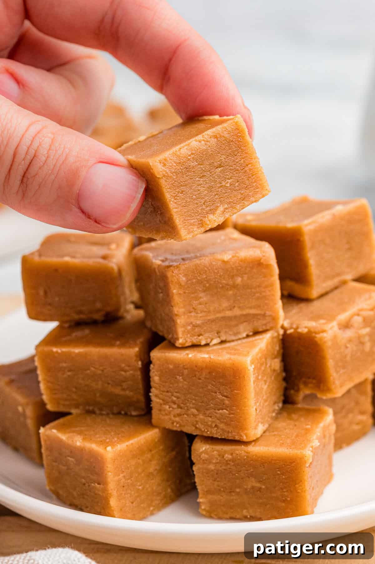Hand picking up a square of peanut butter fudge.