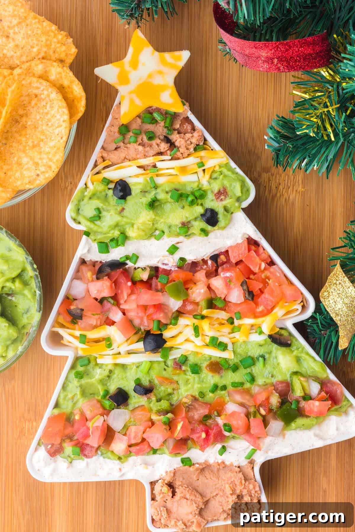 Christmas taco dip with decorations and tortilla chips.