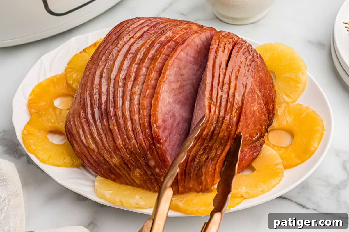 Irresistible Slow Cooker Ham with Pineapple Brown Sugar Glaze 11 A spiral boneless ham beautifully prepared with pineapple slices, set in a slow cooker partially visible in the background, creating an inviting culinary scene.