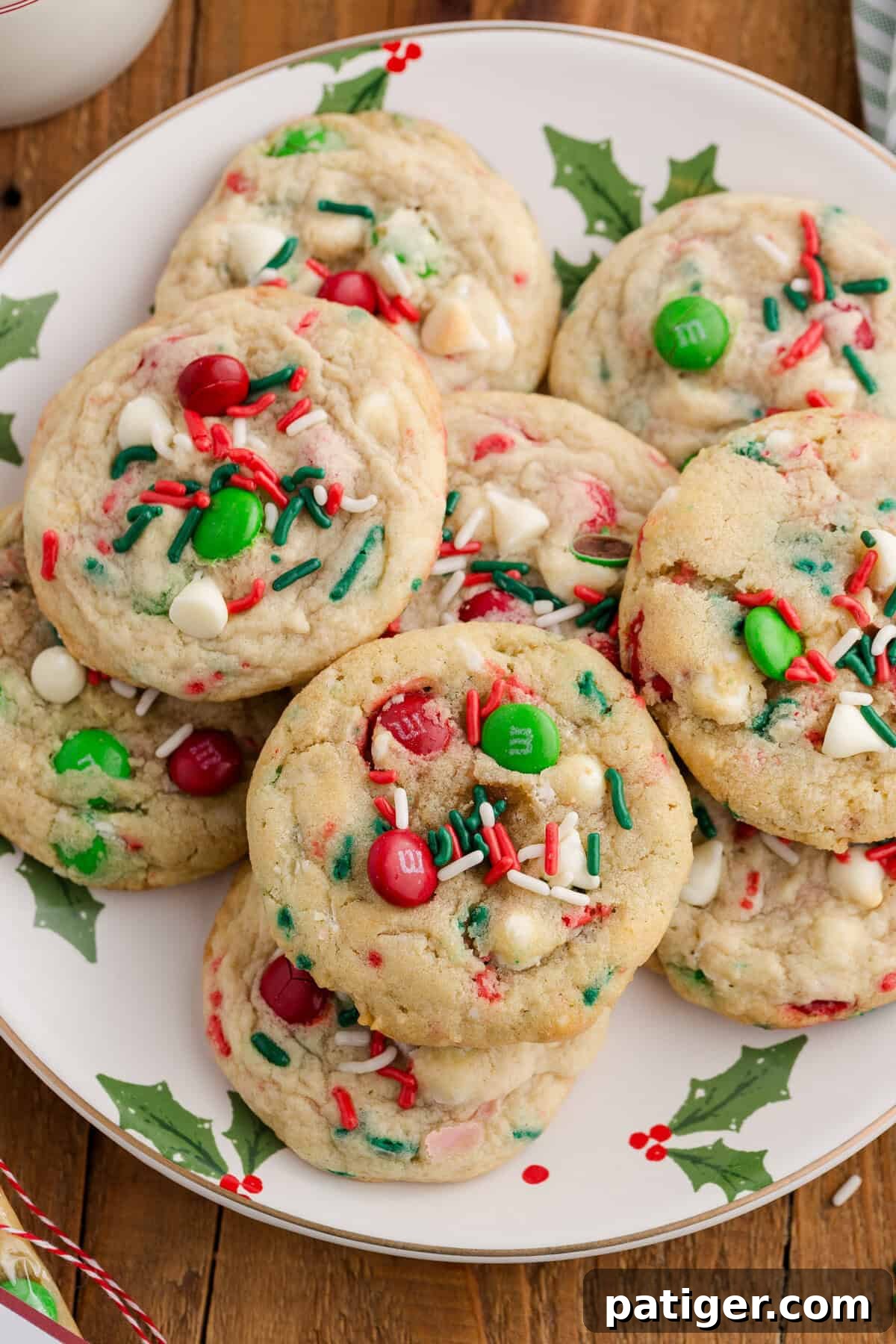 A delightful plate showcasing festive Christmas cookies, generously studded with vibrant red and green M&Ms, rich white chocolate chips, and a scattering of red, green, and white sprinkles, capturing the essence of holiday cheer.