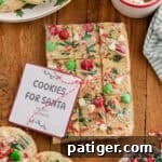 Wrapped break and bake Christmas cookie dough with festive toppings and a “Cookies for Santa” label.