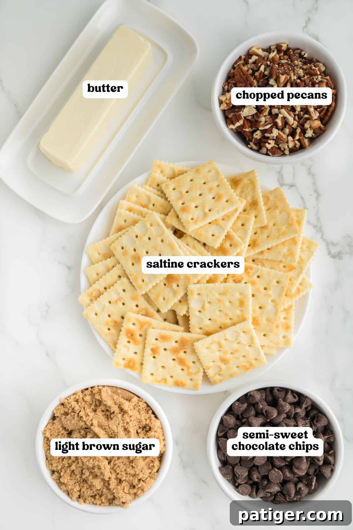 Top-down view of five labeled ingredients for saltine cracker toffee: a plate of saltine crackers, bowls of light brown sugar, semi-sweet chocolate chips, chopped pecans, and a stick of butter. 