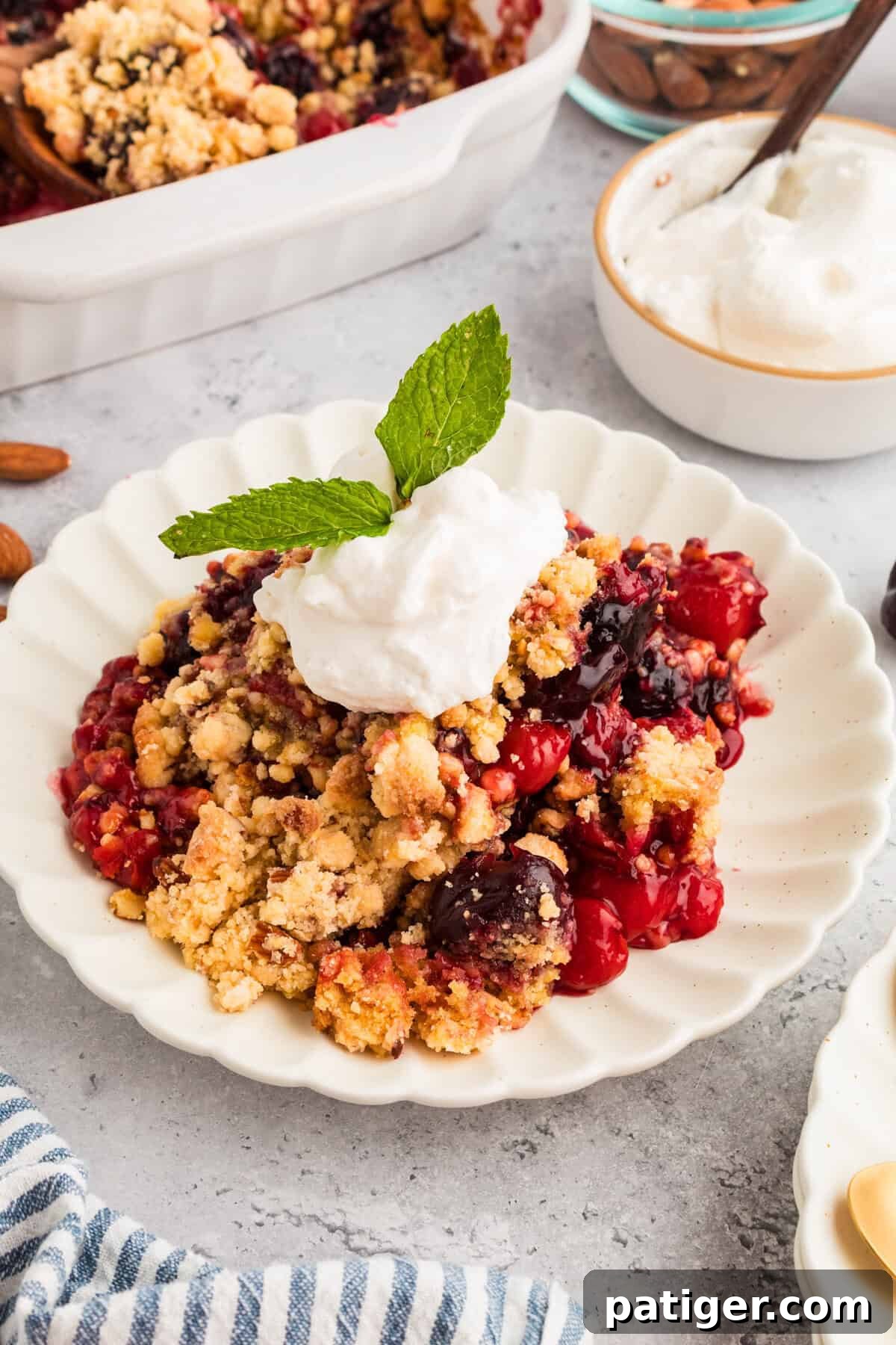Cherry cobbler with cake mix topped with whipped cream and mint, presented beautifully for serving.