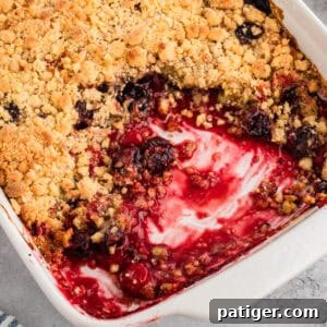 Cherry cobbler with cake mix in a white baking dish, showing a golden crumbly topping and a cherry filling.