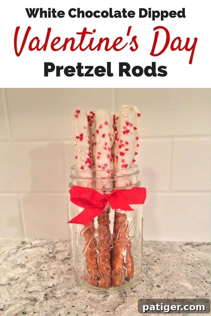 A close-up shot of a single white chocolate-dipped pretzel rod, beautifully adorned with heart sprinkles, highlighting its perfect coating and festive appeal.