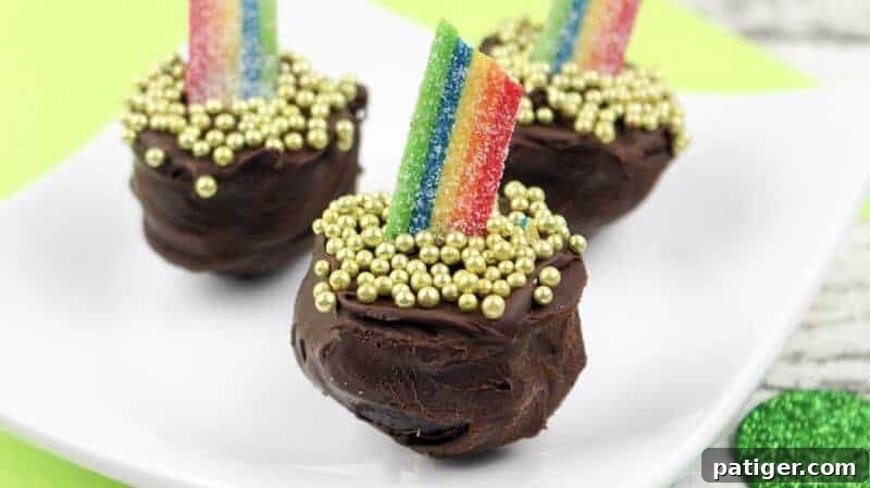 Gold-dusted Oreo cookie truffles adorned with vibrant rainbow sour candies, resembling a pot of gold at the end of a rainbow, a perfect St. Patrick's Day dessert.