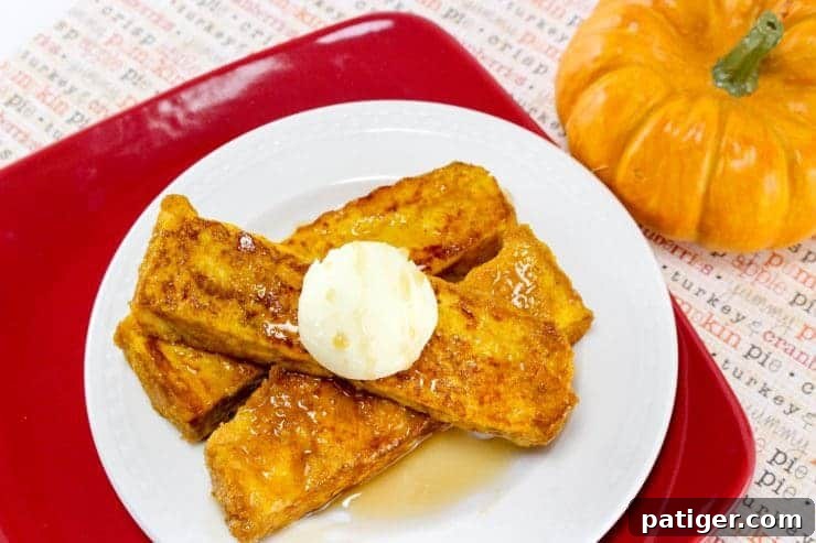 Three pumpkin French toast sticks on plate with syrup and butter.