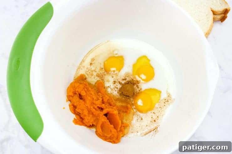 Eggs, pumpkin spice, pumpkin puree and milk in a mixing bowl.