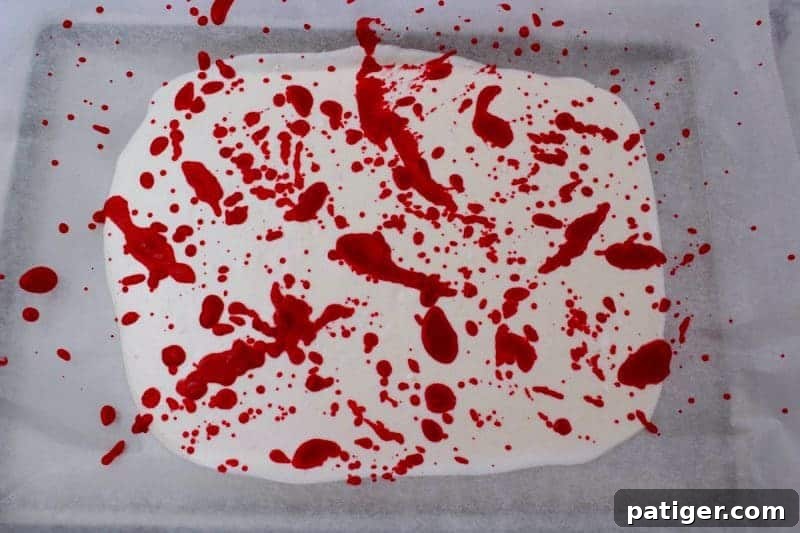 The white melted candy splattered with red melted candy in a blood-like fashion.