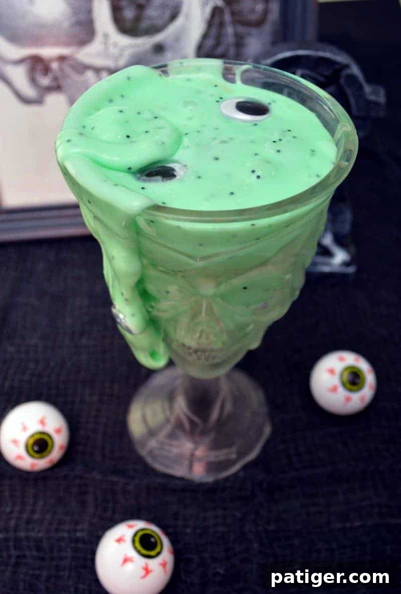 Gooey and jiggly, with black glitter and googly eyes, this DIY green monster slime recipe is easy to make and lots of fun to play with!