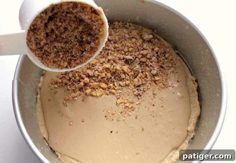 A cup of streusel topping sprinkled over the cream cheese filling layer.