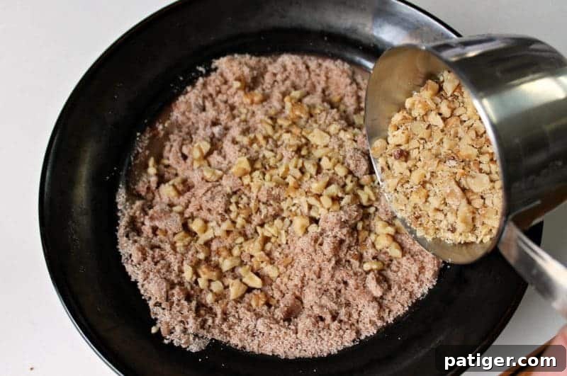 Bowl of streusel mixture with melted butter, sugar, cinnamon, flour, salt, and walnuts.