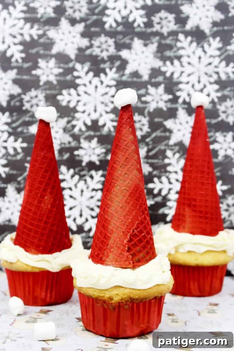 A festive display of Santa Hat Cupcakes, topped with red sugar cones and mini marshmallows, perfect for Christmas celebrations.