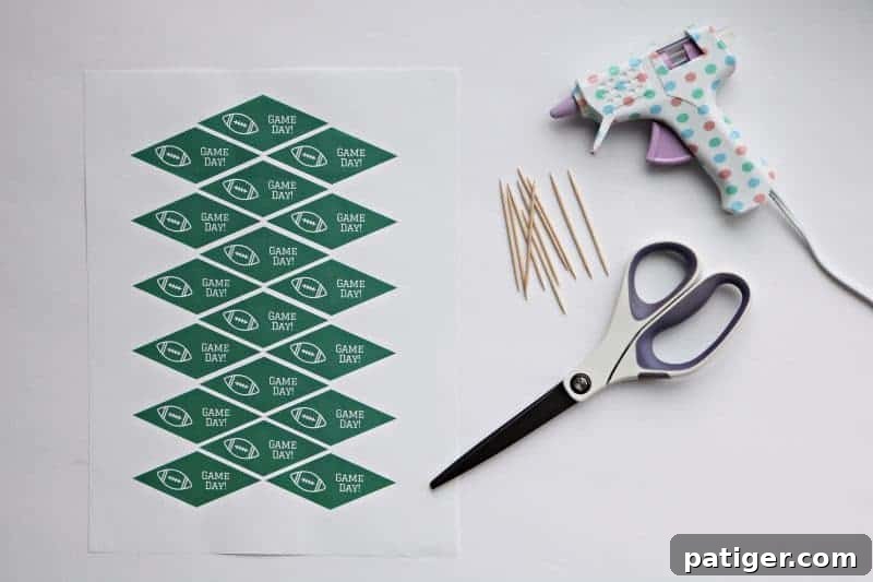 Materials for making DIY Game Day toothpick toppers, including printed flags, toothpicks, and glue gun.