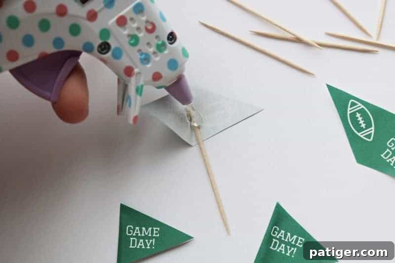 Image illustrating how to fold and glue a toothpick flag topper onto a toothpick.