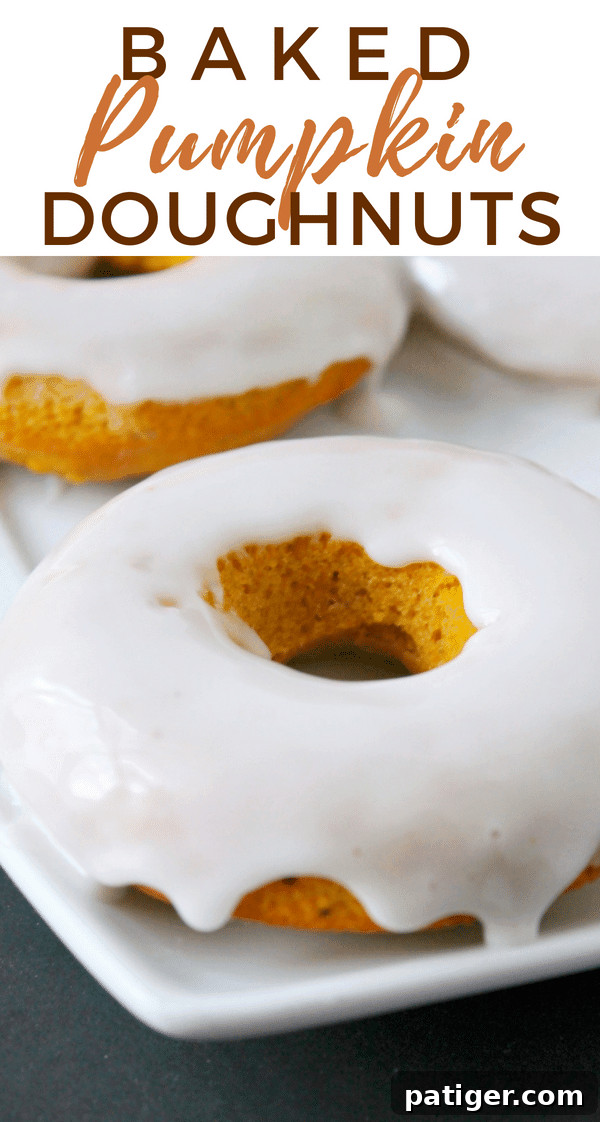 Baked pumpkin doughnuts served warm and smothered with glaze are the perfect Fall recipe for breakfast and dessert alike.