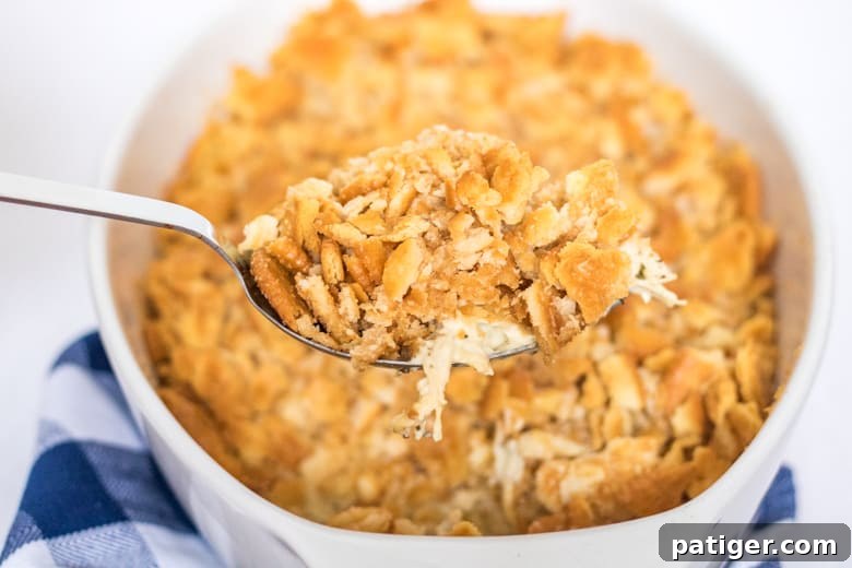 Spoonful of Ritzy Chicken Casserole being scooped from casserole dish, showing the creamy texture.