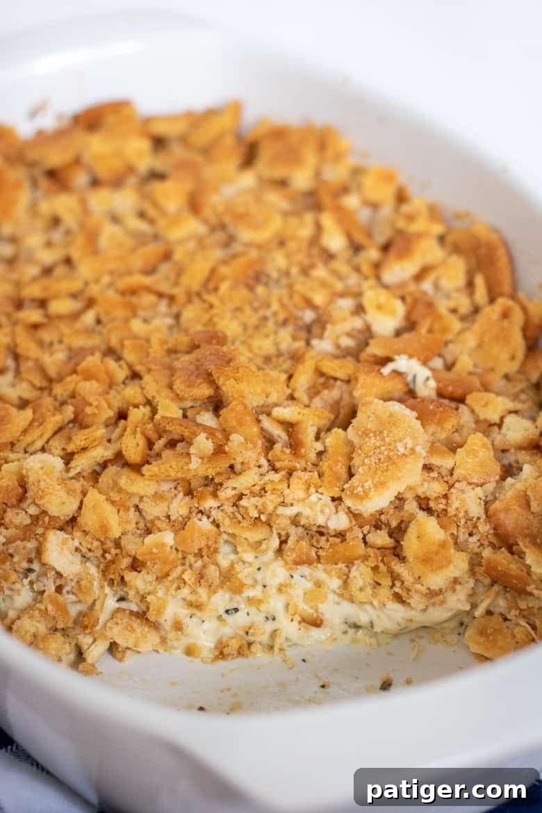 Ritz Chicken Casserole topped with crushed ritz crackers in white baking dish, ready to be served.
